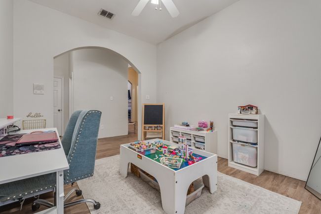 Playroom featuring arched walkways, light wood-type flooring, and a ceiling fan | Image 9