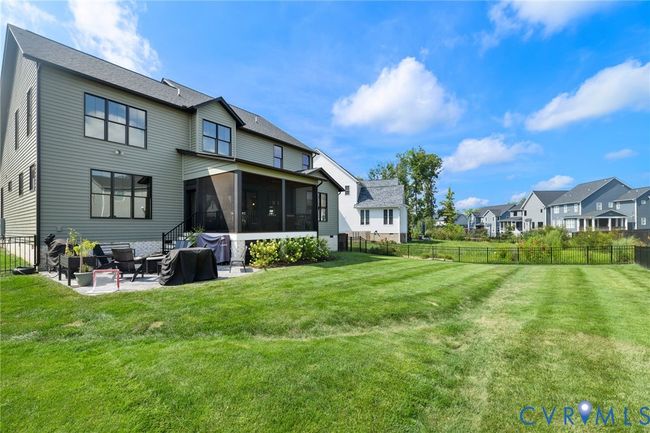 Back of property featuring a sunroom, a patio, a fenced backyard, and a residential view | Image 44