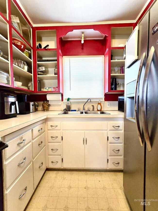 Kitchen with stainless steel refrigerator with ice dispenser, light countertops, and white cabinetry | Image 4