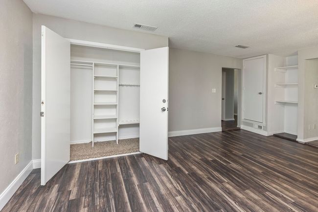 Unfurnished bedroom featuring wood finished floors, a textured ceiling, and baseboards | Image 14