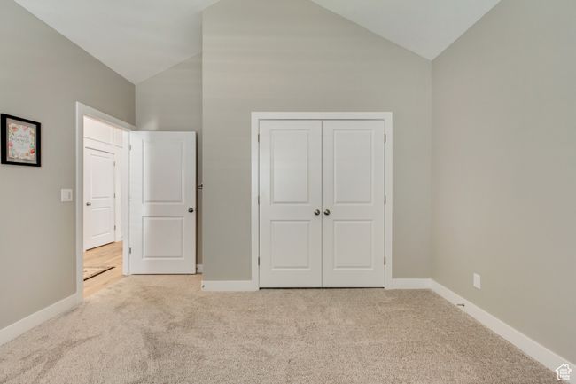 Unfurnished bedroom featuring high vaulted ceiling, carpet, and baseboards | Image 26