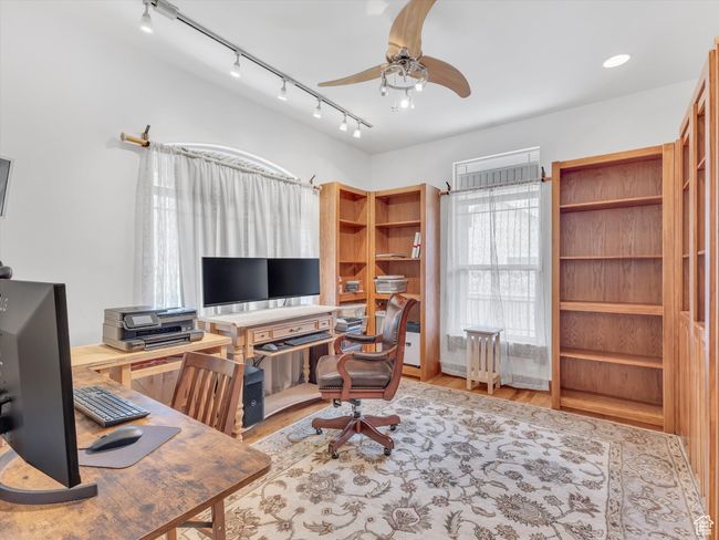 Office area with a ceiling fan, wood finished floors, and rail lighting | Image 16