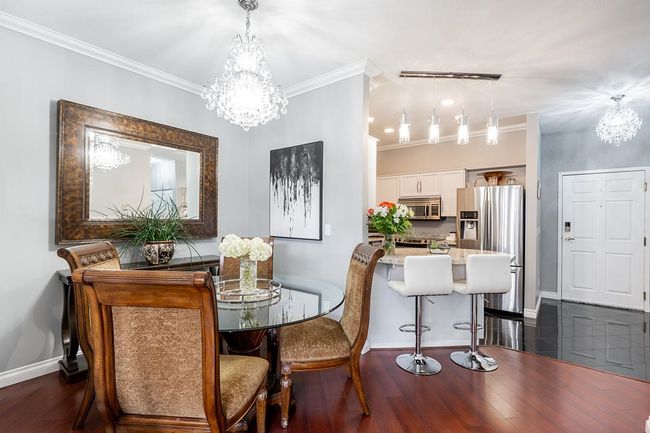 Dining room featuring crown molding, baseboards, dark wood-style flooring, and a chandelier | Image 9