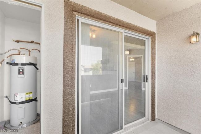 View of exterior entry with strapped water heater and stucco siding | Image 23