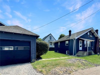 View of side of property with a garage and a lawn | Image 3