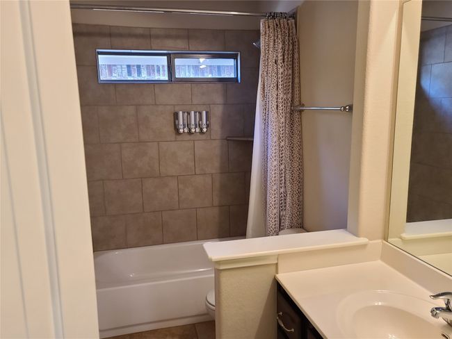 Bathroom featuring vanity, shower / bath combination with curtain, and tile patterned flooring | Image 25