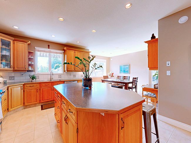 Kitchen with a center island, recessed lighting, healthy amount of natural light, decorative backsplash, and light tile patterned floors | Image 6