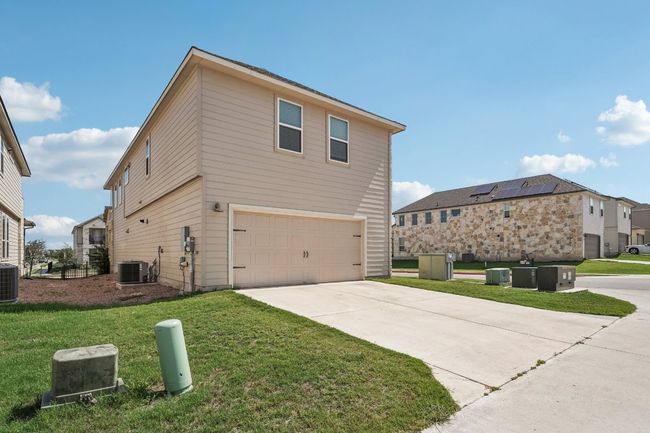 View of home's exterior with a garage, cooling unit, a lawn, and concrete driveway | Image 23