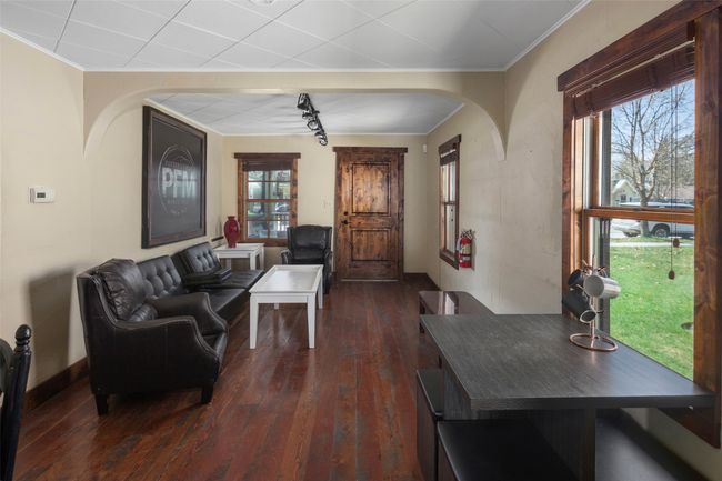 Living area featuring plenty of natural light, crown molding, dark wood-style floors, and arched walkways | Image 10