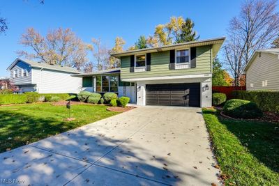 Split level home featuring a garage and a front yard | Image 3