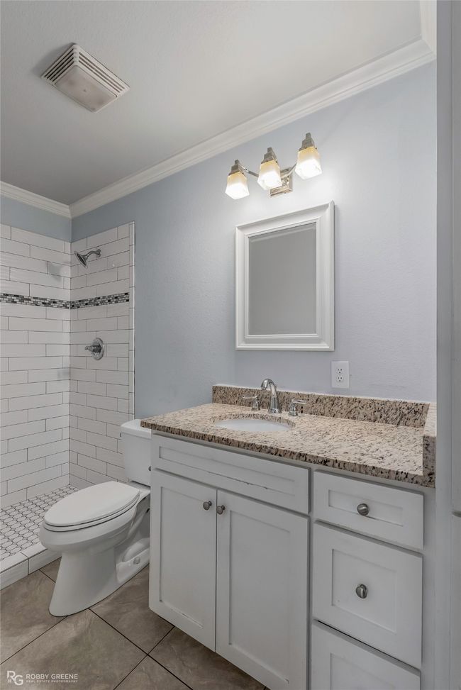 Full bath featuring a shower stall, crown molding, visible vents, toilet, and vanity | Image 16