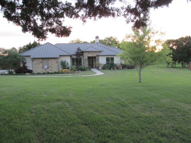 Single story home with a standing seam roof, stone siding, and lovely lot | Image 33