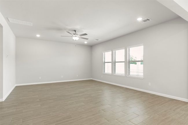 Empty room featuring ceiling fan, baseboards, light wood-type flooring, and recessed lighting | Image 6