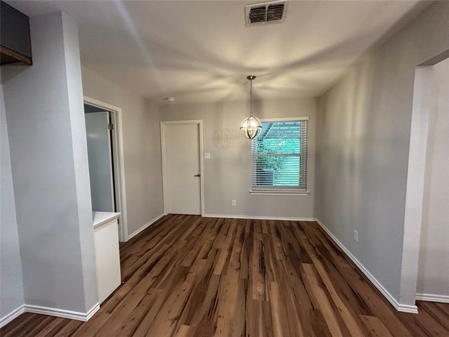 Unfurnished dining area with dark wood-style flooring and a chandelier | Image 20