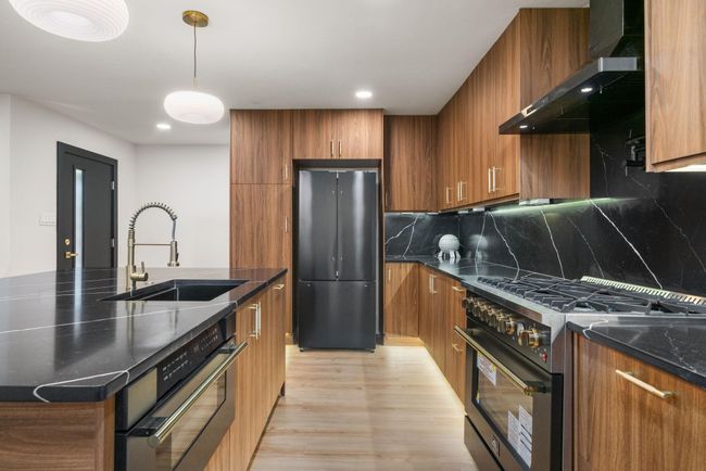 Enjoy a 36” gas range, pull-out microwave drawer, and hidden panel dishwasher | Image 12