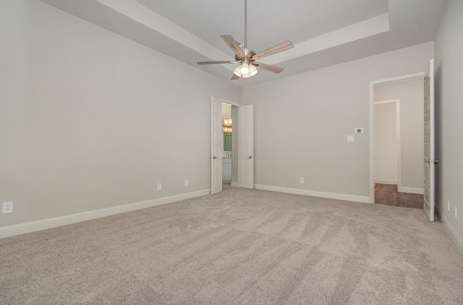 Unfurnished bedroom featuring light carpet, baseboards, and ceiling fan | Image 12