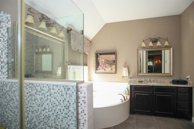 Bathroom featuring vanity, tiled shower, a bath, tile patterned flooring, and lofted ceiling | Image 21