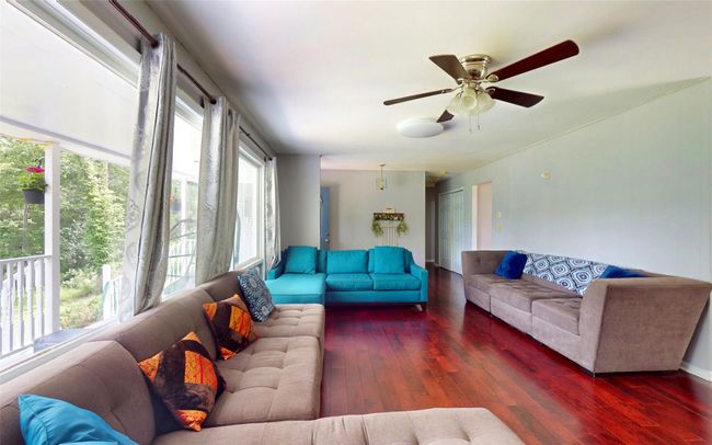 Living room featuring wood-type flooring and ceiling fan | Image 16