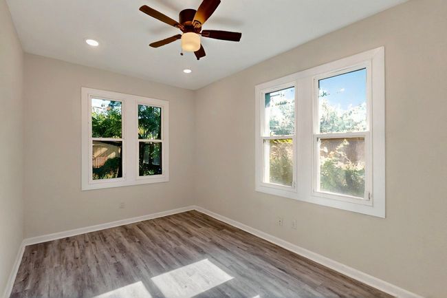 Spare room with wood finished floors, baseboards, ceiling fan, and recessed lighting | Image 10