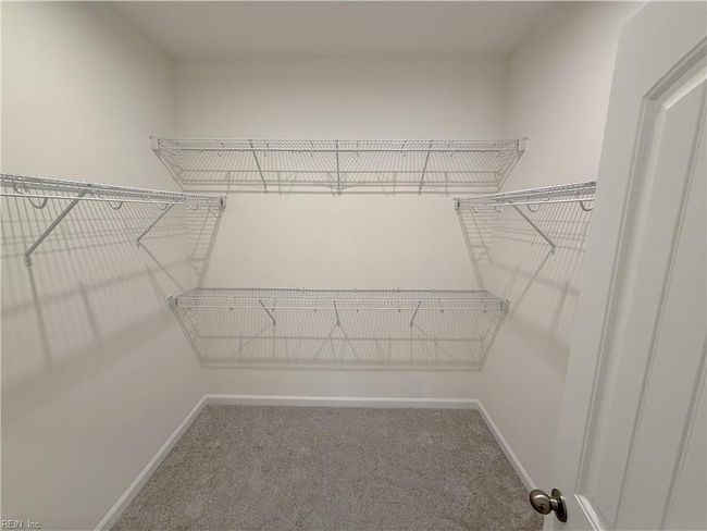 A first-floor primary suite features a walk-in closet and an ensuite bath with double vanity. | Image 10