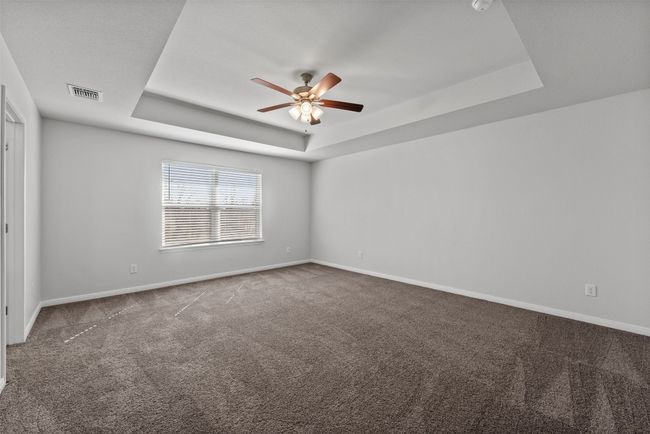 Spare room with a raised ceiling, carpet, and a ceiling fan | Image 23