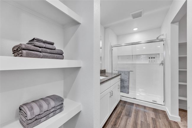 Full bathroom with a stall shower, visible vents, wood finished floors, and vanity | Image 21