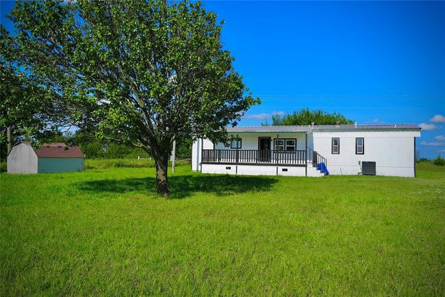 Back of house with central AC unit, a lawn, and covered porch | Image 14