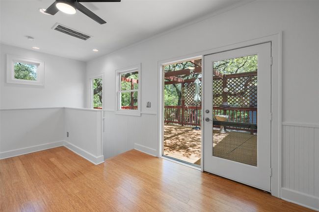 Doorway to outside featuring visible vents, a ceiling fan, light wood-style floors, recessed lighting, and a wainscoted wall | Image 23