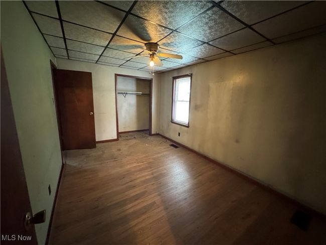 Unfurnished bedroom with light wood-type flooring, baseboards, visible vents, a closet, and a paneled ceiling | Image 7