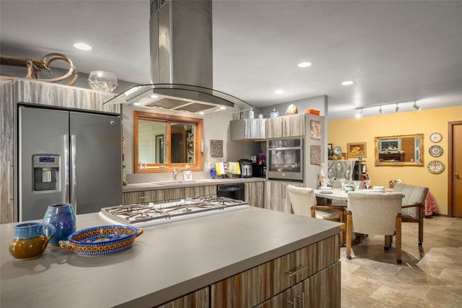 Kitchen featuring island range hood, appliances with stainless steel finishes, a sink, modern cabinets, and recessed lighting | Image 27