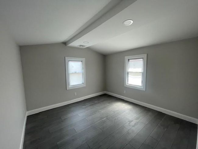 Empty room with lofted ceiling with beams, baseboards, and a healthy amount of sunlight | Image 6