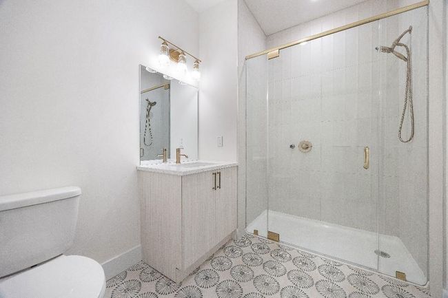 Full bath with toilet, a shower stall, vanity, and baseboards | Image 28
