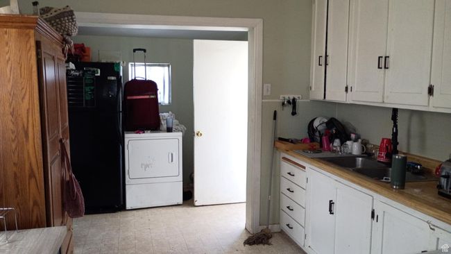 Kitchen featuring white cabinetry, freestanding refrigerator, and light countertops | Image 26