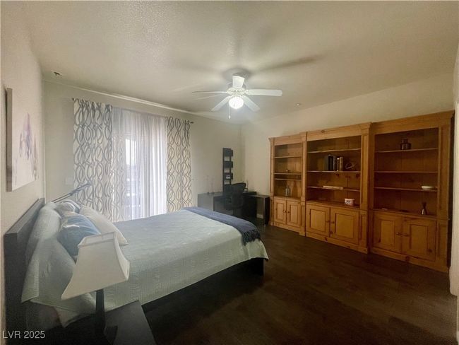 Bedroom featuring dark wood-style floors, a textured ceiling, and ceiling fan | Image 26