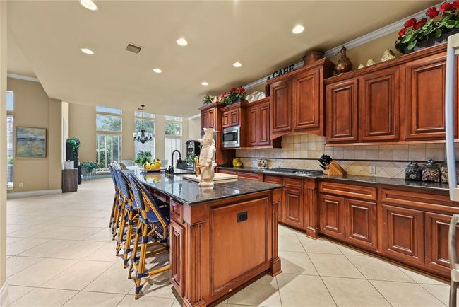 The sweeping kitchen at the heart of the home boasts enough granite counter top space and storage cabinets for casual family meals or hosting large gatherings. | Image 7