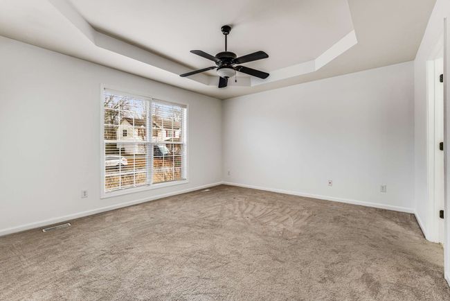 Primary en-suite bedroom features tray ceiling with fan | Image 15