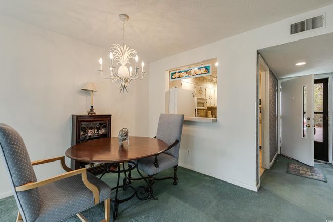 Dining area featuring carpet, baseboards, a chandelier, and visible vents | Image 10