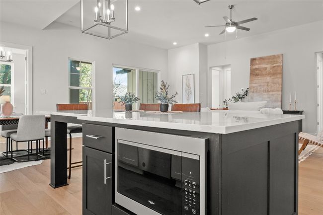 Kitchen with stainless steel microwave, recessed lighting, light wood finished floors, and light countertops | Image 15