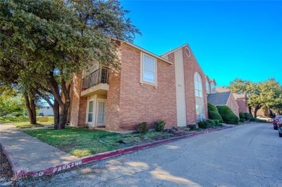 View of property exterior featuring a lawn and a balcony | Image 1