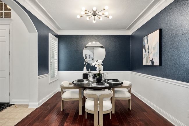 Dining area featuring arched walkways, a notable chandelier, crown molding, and wood finished floors | Image 8
