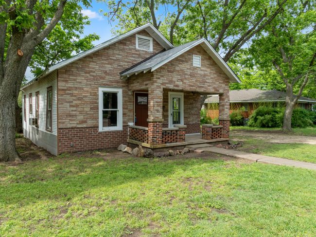 View of front facade featuring covered porch, a front lawn, and brick siding | Image 4