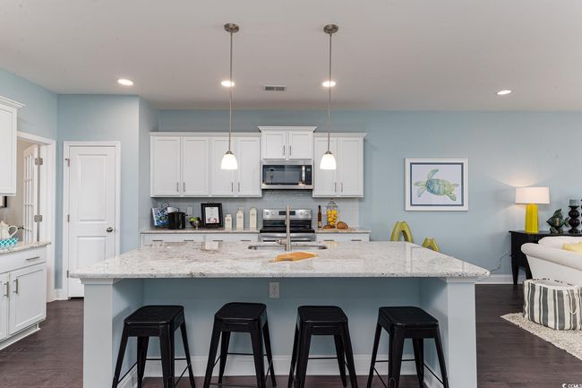 Kitchen with open floor plan, appliances with stainless steel finishes, a sink, and white cabinets | Image 4
