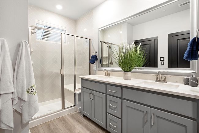 Full bath featuring a stall shower, double vanity, and light wood-type flooring | Image 15