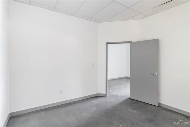 Empty room featuring a drop ceiling, concrete flooring, and baseboards | Image 32