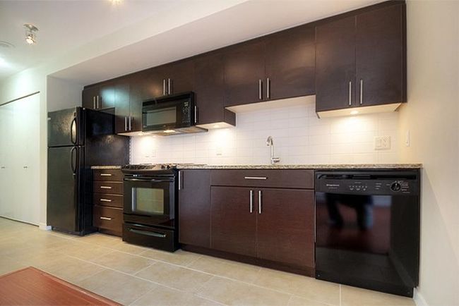 Kitchen featuring black appliances, dark brown cabinetry, tasteful backsplash, and light stone counters | Image 16