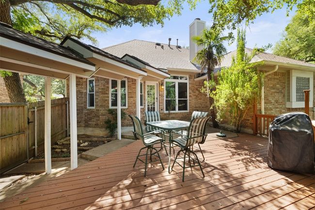 Wooden deck with fence, area for grilling, and outdoor dining area | Image 32
