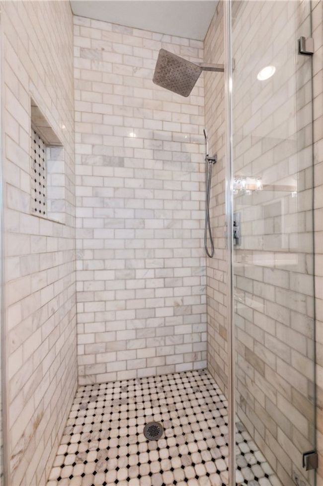 The primary bathroom also incorporates a large walk-in shower with a frameless glass enclosure. | Image 17