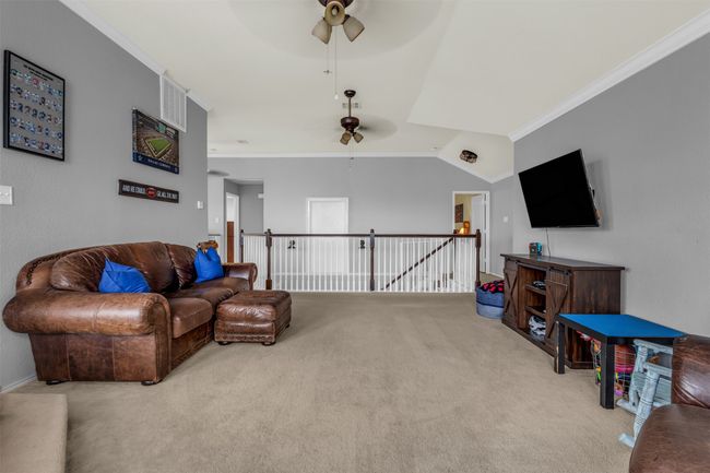 Living room with ceiling fan, light carpet, and ornamental molding | Image 25