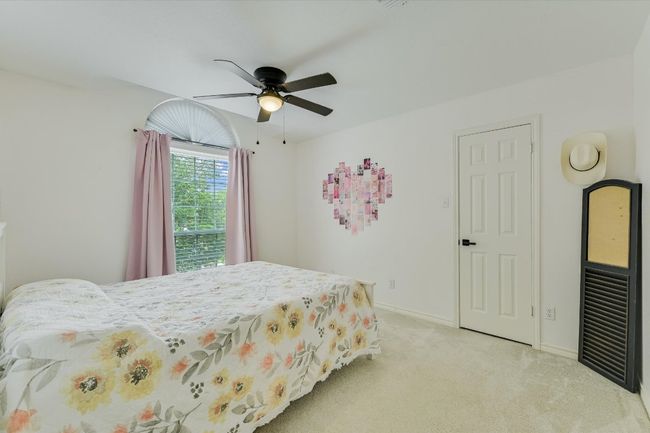 Bedroom with light colored carpet, baseboards, and a ceiling fan | Image 24