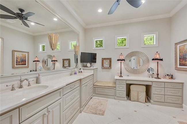 Bathroom with a ceiling fan, double vanity, ornamental molding, plenty of natural light, and tile patterned floors | Image 11